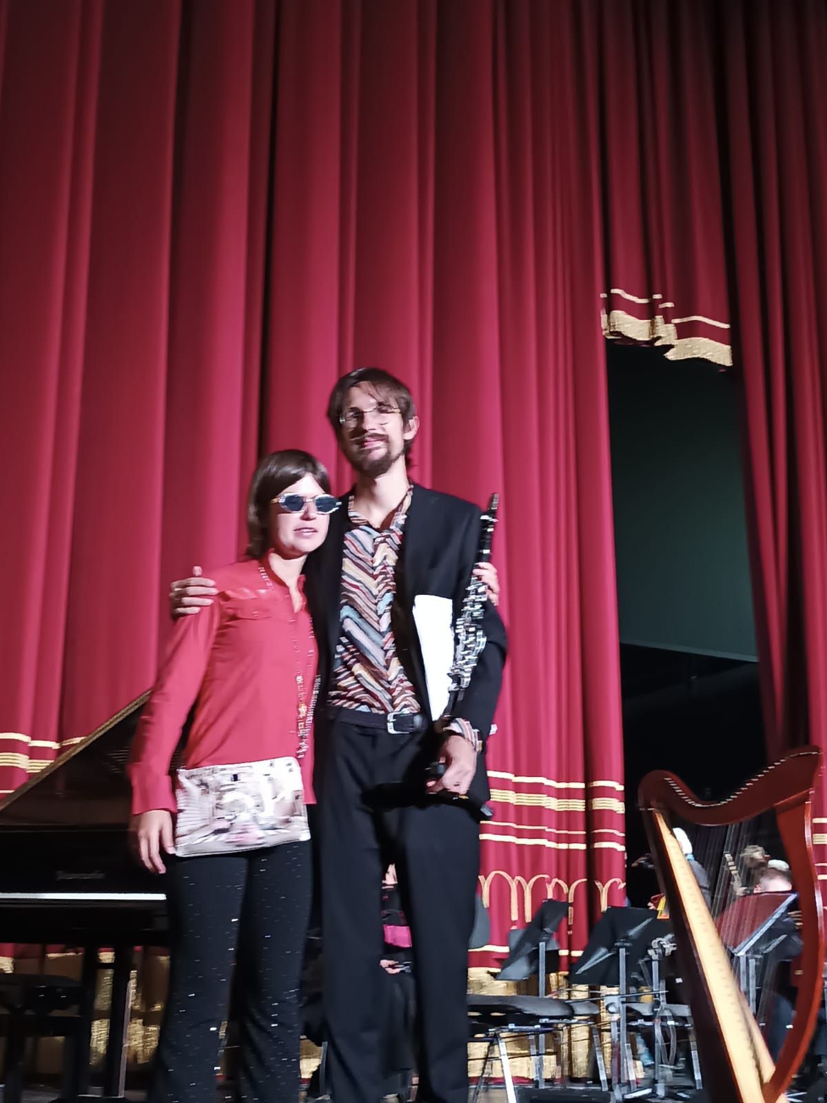 Anna sul palco davanti al sipario rosso